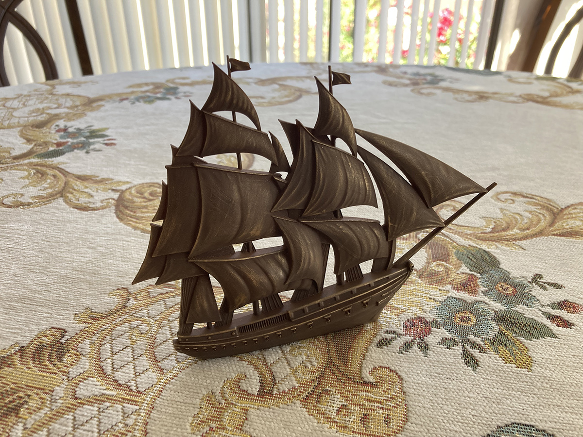 Freestanding sailing ship bas-relief sculpture in antique bronze finish, presented as a refined tabletop decorative object