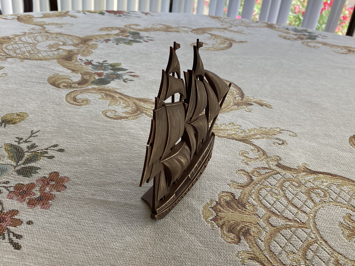 Compact sailing ship bas-relief sculpture with antique bronze finish, showing depth, thickness, and freestanding structure on a tabletop