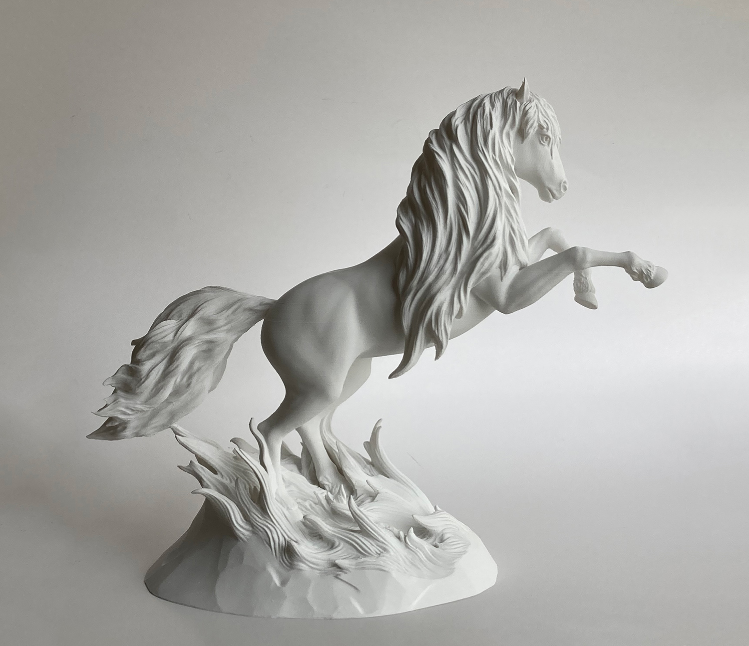 White horse sculpture in a classical plaster-like finish, emphasizing form, anatomy, and sculptural light