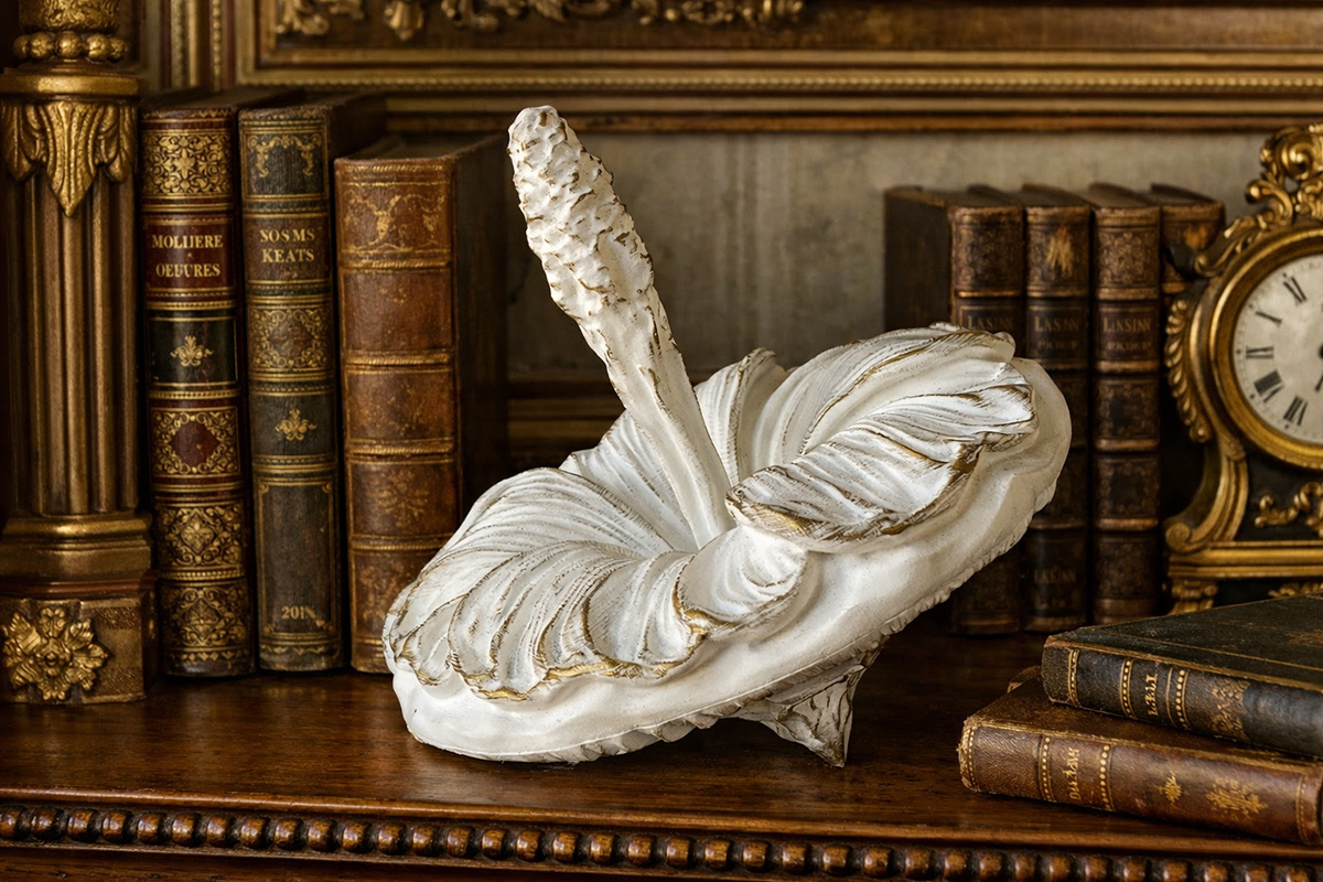 White and gold mallow sculpture displayed among antique books — refined decorative object with vintage character