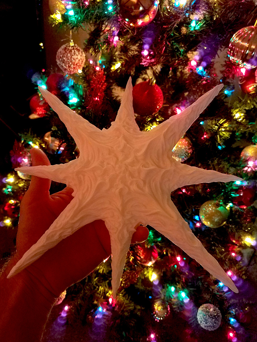 sculptural star used as christmas tree ornament showing integration into festive decor