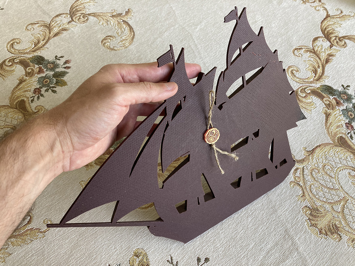 Back view of sailing ship bas-relief sculpture revealing cutout structure and mounting design for wall display