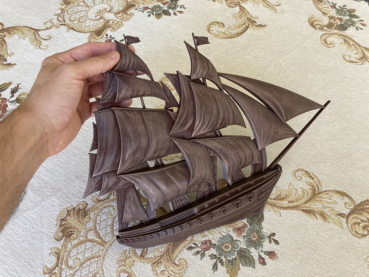 Sailing ship bas-relief sculpture held in hand, showing scale, depth, and refined decorative form