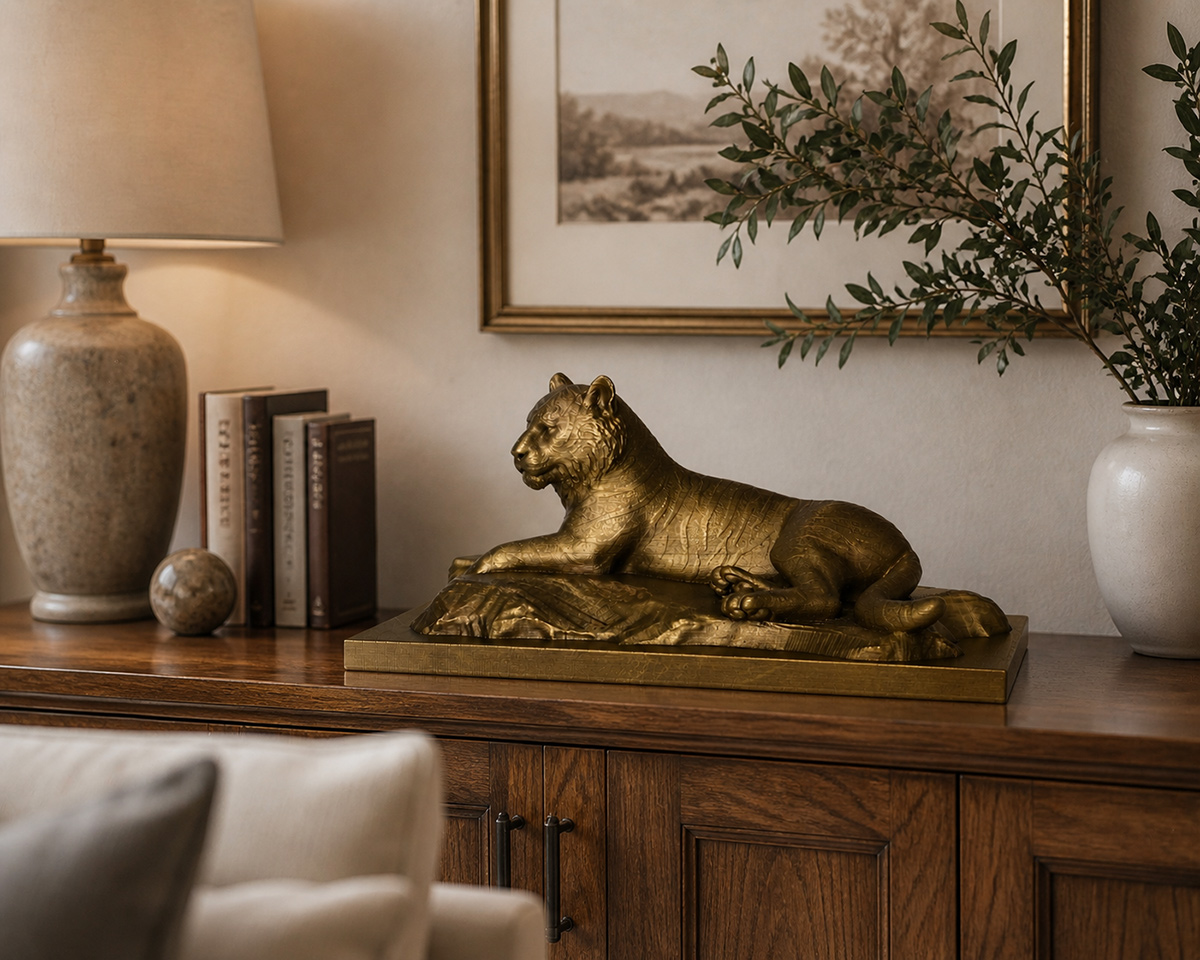 Bronze tiger sculpture displayed on a wooden console table in a warm contemporary living room interior with natural decor and soft lighting